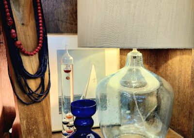 Decorative glassware and layered necklaces on display with warm lighting.