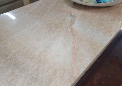 Pink marble table with decorative glass balls on a plate.