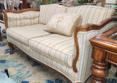 Elegant vintage sofa with striped upholstery and wooden frame.