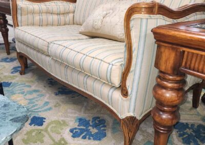 Elegant vintage sofa with wooden frame and plaid upholstery.