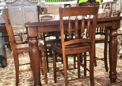 Wooden dining table with four matching chairs on a patterned rug.