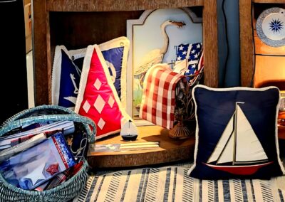 Decorative pillows with nautical and patriotic designs on a cozy shelf.