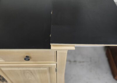 Two black drawboard sheets placed on a wooden cabinet.
