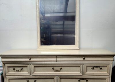 Vintage cream dresser with a matching mirror above it.
