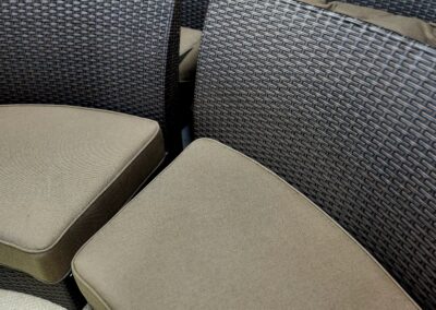 Stacked brown and gray cushioned chairs with woven backs.