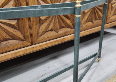 Close-up of a green metal railing with brass accents.