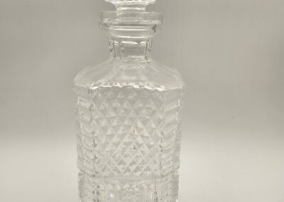 Clear glass decanter with intricate geometric patterns and a stopper.