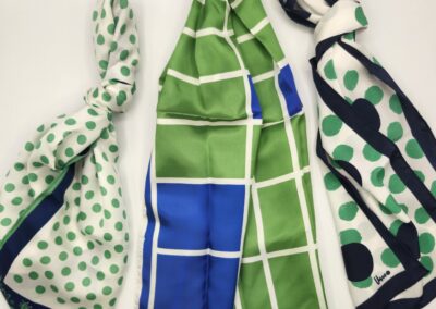 Three colorful patterned scarves laid out on a white surface.