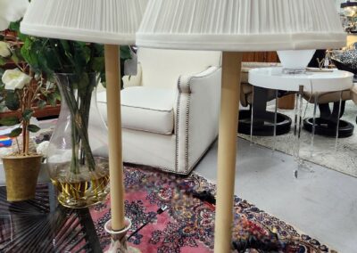 Pair of elegant brass and marble floor lamps with pleated shades on a patterned rug.