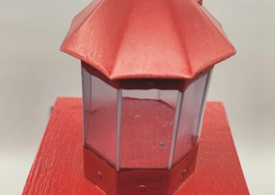 A red lantern with glass panels on a red surface.