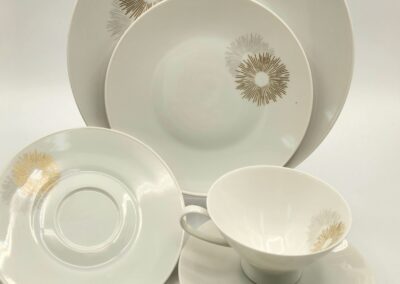 Elegant white porcelain dinnerware set with gold floral designs.
