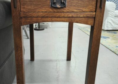 A wooden side table with a single drawer and metal handle.