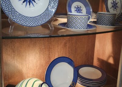 A display of decorative plates with blue and white patterns on wooden shelves.