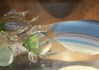 A glass fish sculpture with intricate details and a striped tail.