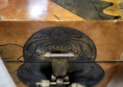 Close-up of a decorative metal clasp on a wooden box.