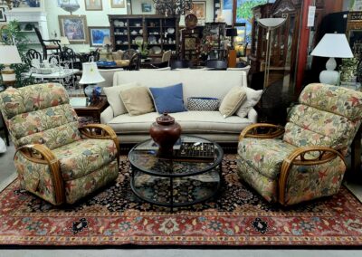 A cozy living room with patterned armchairs and a beige sofa around a glass coffee table.