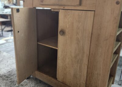 Wooden cabinet with open doors showing two shelves inside.