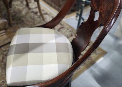 Elegant wooden chair with a checkered cushion seat.