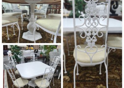 White vintage-style metal outdoor furniture set with ornate designs and cushioned seats.