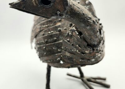 A rustic bird sculpture made from metal and screws.