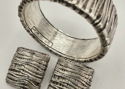 Silver textured bracelet and matching square earrings with a rustic design.