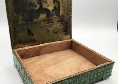 Open decorative box with a textured green exterior and soft pink interior.