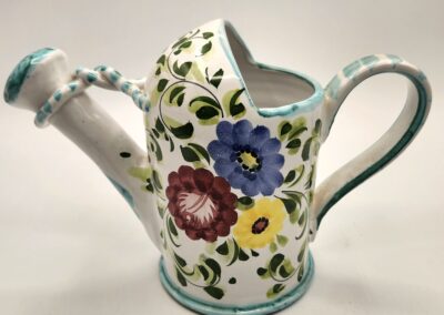 Decorative ceramic watering can with colorful floral patterns.