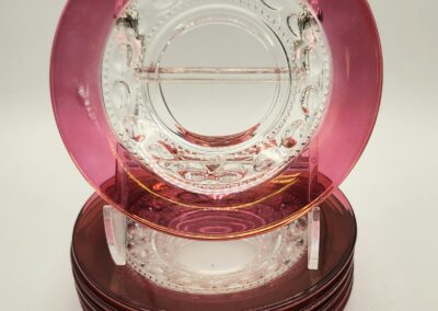Stack of decorative plates with pink and clear glass design.