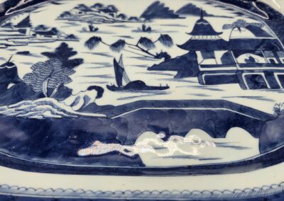 Blue and white porcelain plate with intricate landscape design.