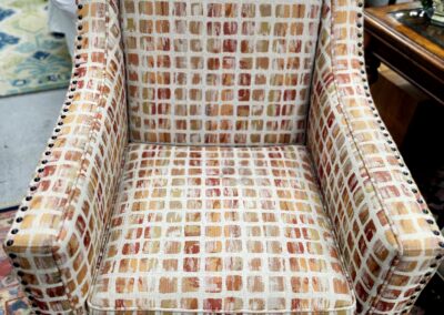 Upholstered armchair with a patterned fabric in a cozy setting.