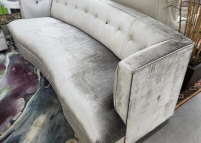 Elegant velvet curved sofa with button tufting.