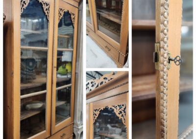 Vintage wooden cabinet with glass doors and intricate carvings.