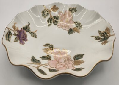 Decorative scalloped porcelain plate with floral patterns.