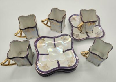 Elegant vintage porcelain tea set with floral designs and purple accents.