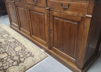 Wooden sideboard with drawers and cabinet doors in a rustic style.