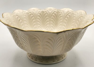 Elegant white ceramic bowl with intricate embossed leaf patterns and gold trim.