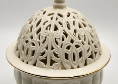 Intricately carved cream ceramic incense burner with floral motifs.