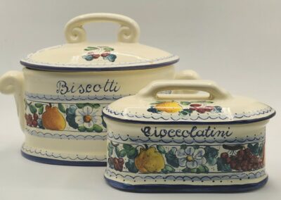 Set of ceramic biscuit and chocolate containers with colorful fruit designs.