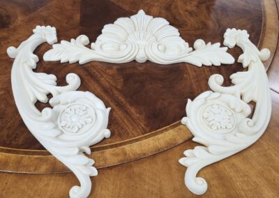 Intricate white decorative pieces on a wooden surface.