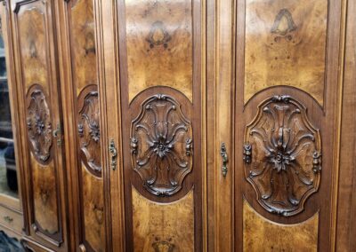 Antique wooden wardrobe with ornate carved panels and rich brown finish.