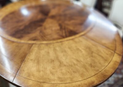Close-up of a polished wooden table with a rich grain pattern.