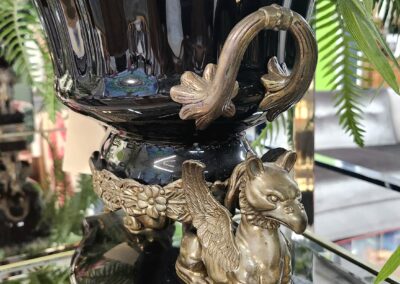 Ornate golden griffin decoration on a black vase.