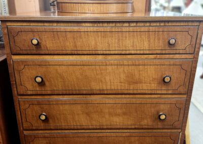 Vintage wooden chest of drawers with four drawers and round knobs.