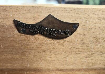 A wooden surface with a small, black, moustache-shaped object.