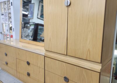 Wooden storage cabinets with multiple drawers and doors in a showroom.