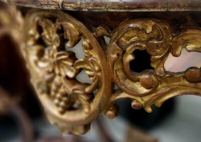 Close-up of ornate golden wood carving on antique furniture.