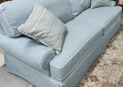 Light blue upholstered sofa with cushions in a cozy living room.
