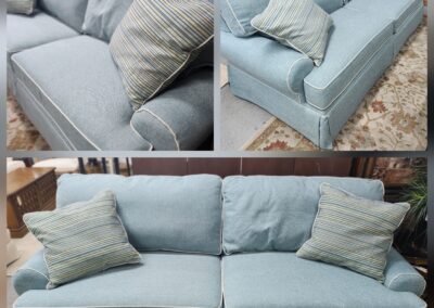 Light blue fabric sofa with cushions in a cozy living room.