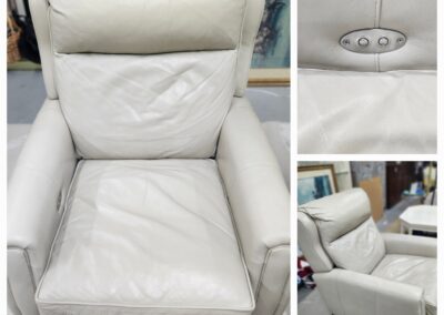 Worn white leather reclining chair with visible creases and stains.