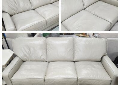 Cream-colored leather sofa with visible wear and stains.